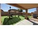 View of a backyard that features a shaded pergola and green artificial turf at 22461 W Woodlands Ave, Buckeye, AZ 85326