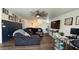 Living room with sectional sofa, hardwood floors, and decorative accent wall with Gathering photos at 22461 W Woodlands Ave, Buckeye, AZ 85326