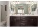 Bathroom featuring double sinks, dark cabinets, and a large mirror at 22552 E Via Estancia --, Queen Creek, AZ 85142