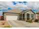 Charming single-story home featuring a two-car garage and a well-maintained front yard under a partly cloudy sky at 22552 E Via Estancia --, Queen Creek, AZ 85142