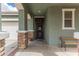 Welcoming front porch with stone accents, a seating bench, and a stylish secure door, enhancing the home's curb appeal at 22552 E Via Estancia --, Queen Creek, AZ 85142