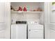 Functional laundry room with a white washer and dryer, complemented by shelving for organized storage at 22552 E Via Estancia --, Queen Creek, AZ 85142