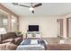 Spacious living room featuring a ceiling fan, comfortable sofas, and a mounted television at 22552 E Via Estancia --, Queen Creek, AZ 85142