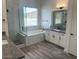 Luxurious bathroom with double vanity, marble shower, soaking tub, and wood look tile flooring at 231Xx W Gloria Ln, Wittmann, AZ 85361
