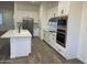 Bright kitchen showcasing an island, stainless steel appliances, and white cabinets with dark hardware at 231Xx W Gloria Ln, Wittmann, AZ 85361
