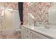 Bathroom featuring stylish wallpaper, a tub with shower, and a double sink vanity with ample storage at 2325 W Mineral Rd, Phoenix, AZ 85041