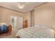 Bedroom with neutral walls, ceiling fan, adjacent bathroom, and a work desk and dresser at 2325 W Mineral Rd, Phoenix, AZ 85041