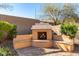 Outdoor fireplace with integrated benches surrounded by pavers and mature trees and landscaping at 2325 W Mineral Rd, Phoenix, AZ 85041