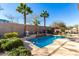 Outdoor swimming pool surrounded by lush greenery, palm trees, and a decorative outdoor fireplace at 2325 W Mineral Rd, Phoenix, AZ 85041
