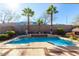 Backyard pool area with palm trees, outdoor fireplace, surrounding landscaping, and mountain views at 2325 W Mineral Rd, Phoenix, AZ 85041