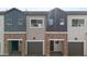 Exterior view of townhomes with brick accents, garage doors, and varying gray siding at 2825 W Eagle Talon Rd, Phoenix, AZ 85085