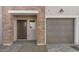 Close up of townhome exterior with brick accents, garage door, and small window by entrance at 2825 W Eagle Talon Rd, Phoenix, AZ 85085