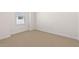 Bright bedroom with neutral carpet, minimalist white walls and a large window, creating a clean and inviting space at 2832 W Eagle Talon Rd, Phoenix, AZ 85085