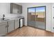 Modern kitchenette includes gray cabinets, light countertops, and sliding glass door to patio at 2835 W Eagle Talon Rd, Phoenix, AZ 85085