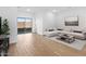 Bright living room features wood-look flooring, a comfortable sectional, and sliding glass doors at 2835 W Eagle Talon Rd, Phoenix, AZ 85085