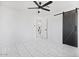 Bright bedroom features stylish tile flooring, a ceiling fan and modern barn door at 2921 W Luke Ave, Phoenix, AZ 85017