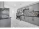 Well-lit kitchen with sleek gray cabinets, stainless steel appliances, and stylish backsplash at 2921 W Luke Ave, Phoenix, AZ 85017