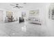 Bright living room featuring white tile flooring and minimalist decor for a modern and airy feel at 2921 W Luke Ave, Phoenix, AZ 85017