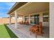 Spacious covered patio with multiple seating areas and artificial turf, perfect for outdoor entertaining at 39758 N Hailey Ln, Queen Creek, AZ 85140