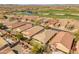 Scenic aerial view of community with golf course, serene pond, and picturesque homes at 41105 N Prestancia Way, Anthem, AZ 85086