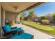 Covered back patio with outdoor seating overlooks the beautifully landscaped backyard with putting green at 41105 N Prestancia Way, Anthem, AZ 85086