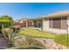 An inviting backyard featuring a putting green, desert landscaping, and a covered patio for outdoor enjoyment at 41105 N Prestancia Way, Anthem, AZ 85086