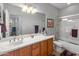 Bathroom features double sinks, wooden cabinets and a shower/tub combo with curtain at 41105 N Prestancia Way, Anthem, AZ 85086