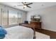 Comfortable bedroom featuring a ceiling fan, hardwood floors, natural light, and a television on a dresser at 41105 N Prestancia Way, Anthem, AZ 85086