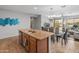 Open concept kitchen boasts granite countertops, stainless appliances, and an eat-in island overlooking the living area at 41105 N Prestancia Way, Anthem, AZ 85086