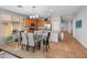 Bright kitchen and dining area features tile floors, wood cabinets, stainless appliances, and a dining table with seating at 41105 N Prestancia Way, Anthem, AZ 85086