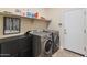 This laundry room features a front loading washer/dryer, overhead shelf, and ample cabinet space at 41105 N Prestancia Way, Anthem, AZ 85086