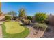 Backyard putting green is surrounded by decorative rocks and lush, mature landscaping at 41105 N Prestancia Way, Anthem, AZ 85086