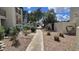 Community walkway with desert landscaping, rocks, and plants leading to parking area at 5518 E Lindstrom Ln # 1034, Mesa, AZ 85215