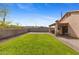 Expansive backyard boasts a well-kept lawn, covered patio, and secure block wall, ideal for outdoor living at 5819 S 10Th St, Phoenix, AZ 85040
