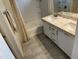 Bathroom features a shower over tub, a vanity with white cabinets and a granite countertop, and grey floor tiles at 5819 S 10Th St, Phoenix, AZ 85040