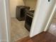 Small laundry room with grey front load washer and dryer sets and tile floors at 5819 S 10Th St, Phoenix, AZ 85040