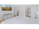 Sunlit main bedroom with modern white furnishings, TV, and an en-suite bathroom for a spa-like experience at 5819 S 10Th St, Phoenix, AZ 85040