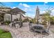 Inviting backyard patio featuring a built-in grill, comfortable seating, and stylish pergola for outdoor entertaining at 5831 N 196Th Ln, Litchfield Park, AZ 85340