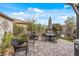 Backyard patio featuring an outdoor table with umbrella, elegant garden decor and comfortable seating at 5831 N 196Th Ln, Litchfield Park, AZ 85340