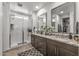 Modern bathroom with a walk-in shower, double sinks, granite counters, and a walk-in closet at 5831 N 196Th Ln, Litchfield Park, AZ 85340