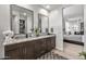 Bright bathroom with dual sinks, granite countertops, modern fixtures, and access to the main bedroom at 5831 N 196Th Ln, Litchfield Park, AZ 85340