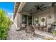 Charming covered patio boasts wicker seating, neutral rug, and ample space for relaxation and entertaining at 5831 N 196Th Ln, Litchfield Park, AZ 85340