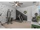 An exercise room with multiple machines, and half the wall painted black and covered in wallpaper at 5831 N 196Th Ln, Litchfield Park, AZ 85340