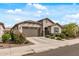 Beautiful home with a well-maintained lawn, mature landscaping, and a two-car garage, offering curb appeal at 5831 N 196Th Ln, Litchfield Park, AZ 85340