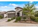 Charming single-story home featuring a manicured front yard, stone accents, and an attached two-car garage at 5831 N 196Th Ln, Litchfield Park, AZ 85340