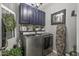 Well-lit laundry room featuring blue cabinets, modern appliances, and stylish decor at 5831 N 196Th Ln, Litchfield Park, AZ 85340
