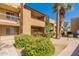 Condo exterior featuring well-maintained landscaping, with mature palm trees and vibrant flowering bushes at 5877 N Granite Reef Rd # 1145, Scottsdale, AZ 85250