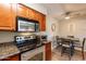 Functional kitchen with stainless steel appliances, laminate flooring, and a cozy dining area at 5877 N Granite Reef Rd # 1145, Scottsdale, AZ 85250