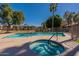 Community pool featuring a hot tub, mature trees, and a clear blue sky, offering a relaxing outdoor space at 5877 N Granite Reef Rd # 1145, Scottsdale, AZ 85250