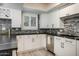 Modern kitchen featuring white cabinets, dark countertops, stainless steel appliances and tile backsplash at 6326 N 86Th N St, Scottsdale, AZ 85250